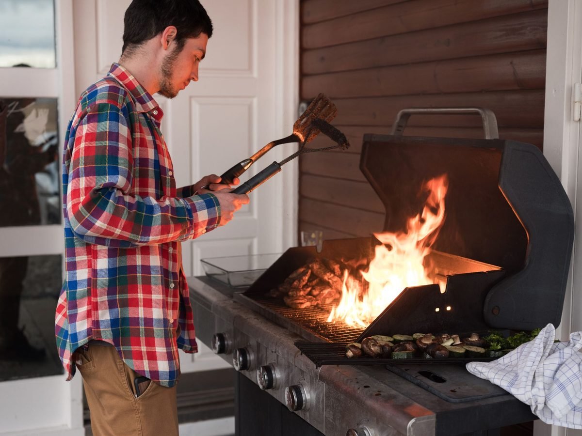 Man grilling outdoors over open flames